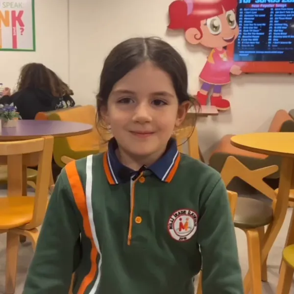 MiniCafe'de, okul formasıyla gülümseyen bir öğrenci